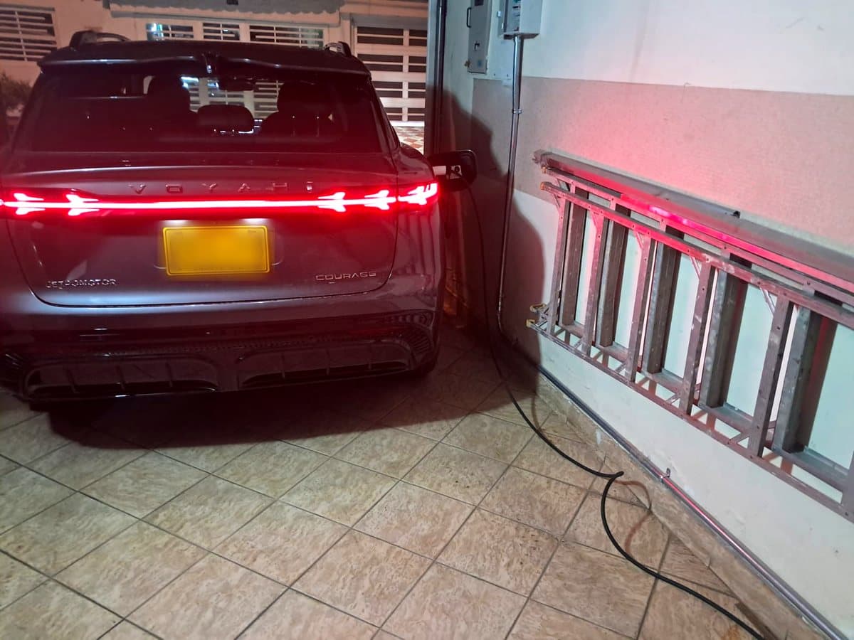 Vehículo eléctrico conectado al cargador en el garaje de una vivienda en Bogotá